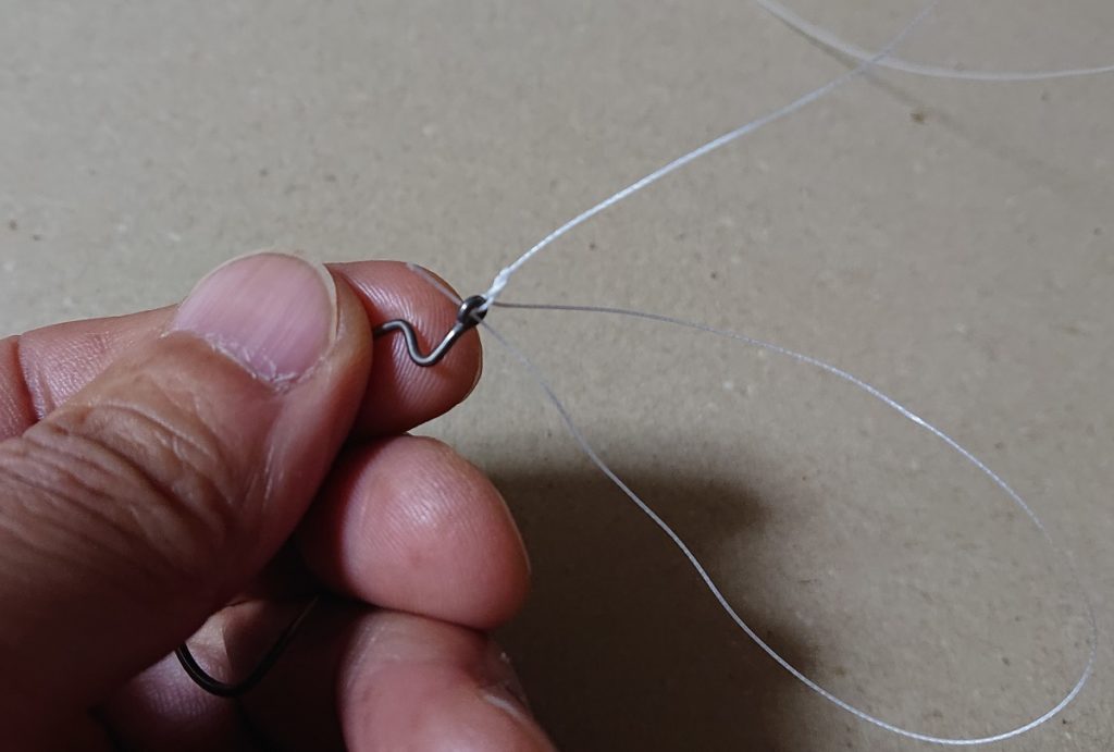 締めこんだら、余ったラインを、フックが上を向く様に、上から下にアイに通します。